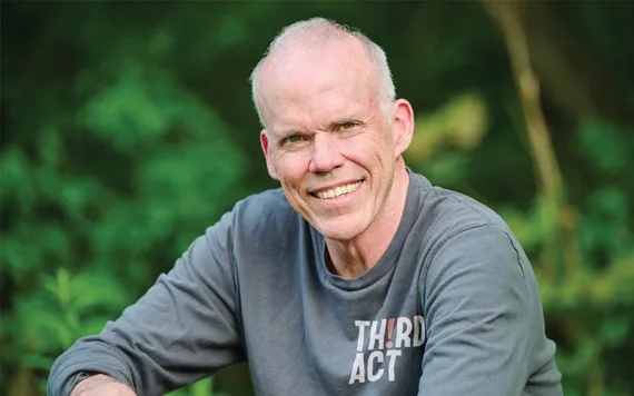 Portrait of Bill McKibben sitting and smiling at the camera