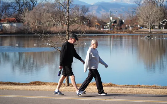 Two people stroll through a snowless Denver park this past winter.