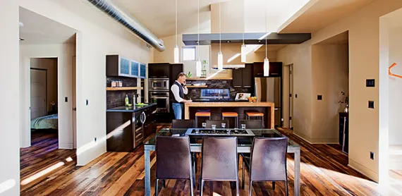 A "light shelf" reflects natural light from high windows deep into the house, showcasing reclaimed-lumber flooring.
