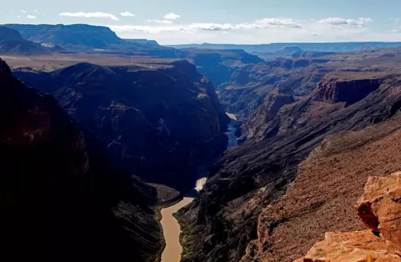 This photo from Toroweap looking west toward Whitmore Canyon shows Lava Falls on the north (right) canyon wall. A second lava falls can be seen in the distance. The white of Lava Falls rapids can be seen in the river.