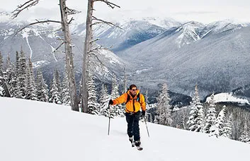 Whitefish local Brad Lamson nears the top of the group's first climb, with the peaks of Glacier National Park behind