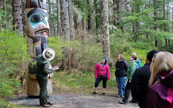 Ranger showing park guests a totem pole at Sitka National Historical Park.