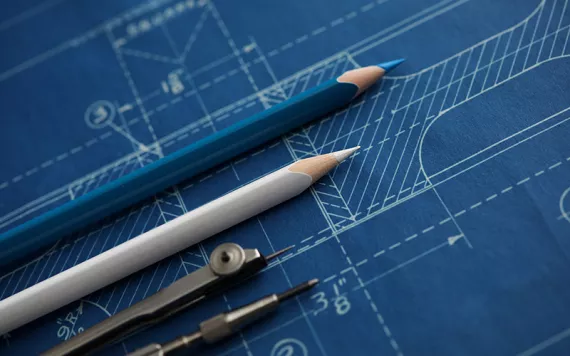 Indigo-colored engineering drawning with two nicely sharpened pencils and a compass