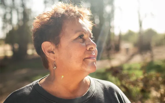 Rosanna Esparza wears a black shirt and looks off to the side as the sun shines on her.