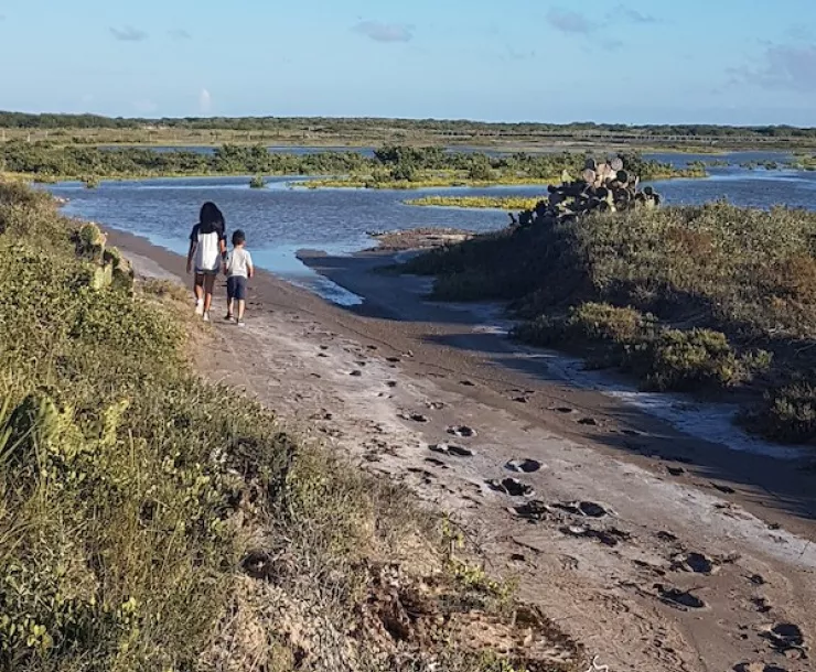 kids walking on marshy coastal area where Rio Grande LNG is planned to be built