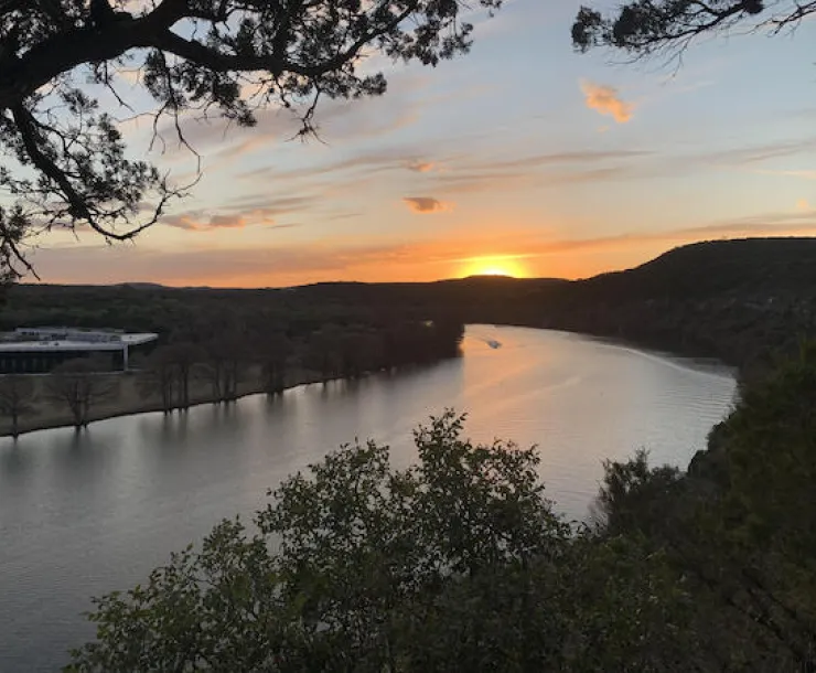 The sun sets over a river.