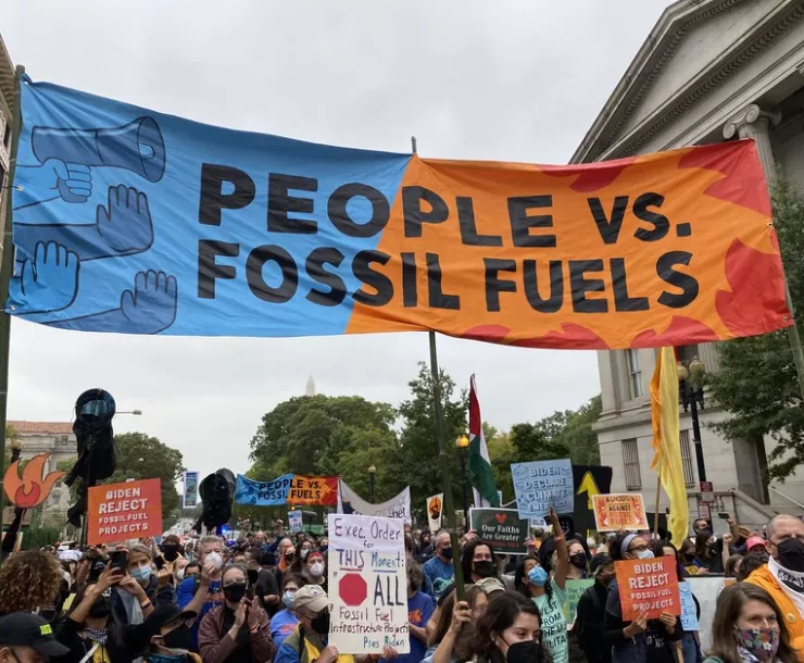 Protest with sign that says people vs fossil fuels
