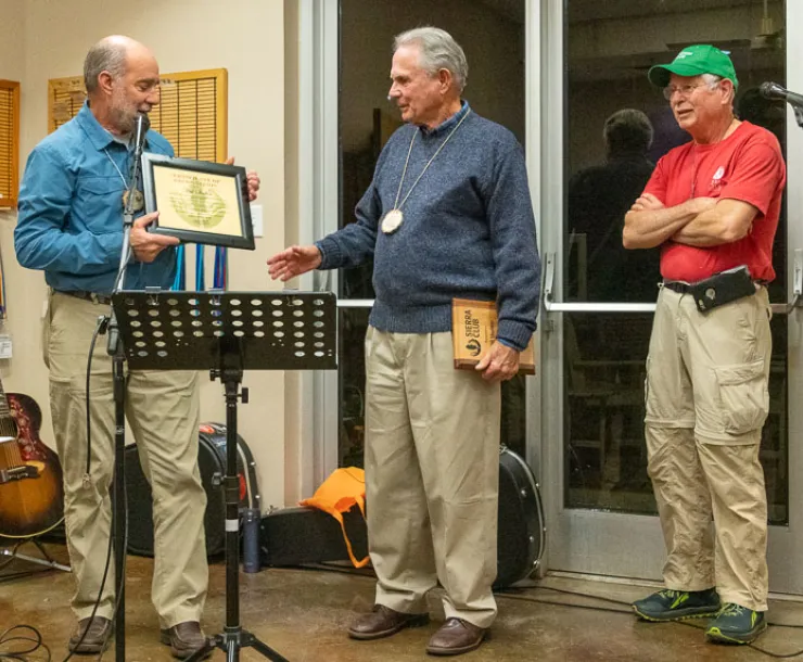 Will Skelton receives an award in front of darkened windows