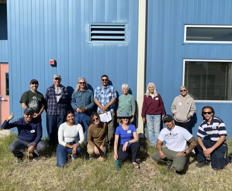 Photo of a group of people smiling in front of a building