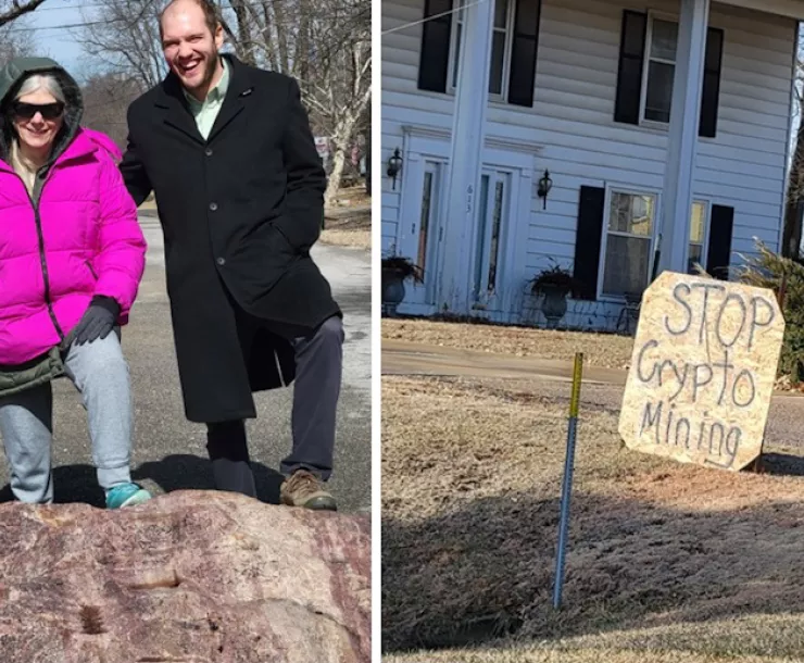 Man and woman on McClouth rock in the road, stop cryptomining protest sign in front of house