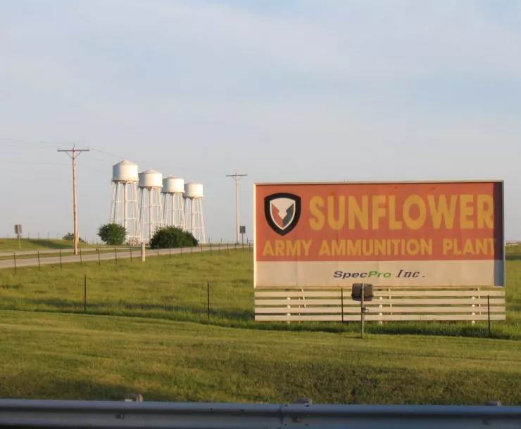 Sunflower Ammunition Plant billboard in green field