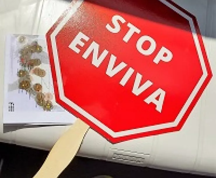 A hand sign shaped like a stop sign says STOP ENVIVA