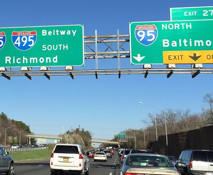 Several lanes of Cars traveling on I-495 under green sign 