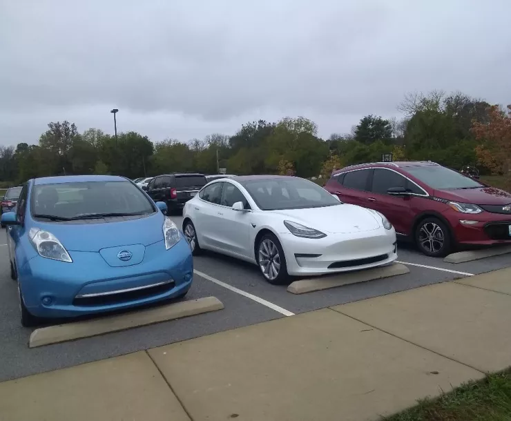 Three electric vehicles lined up in parking spots