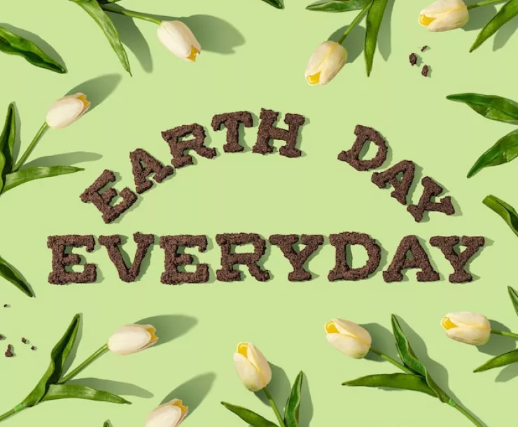 Earth Day Everyday written in dirt with tulips around it.