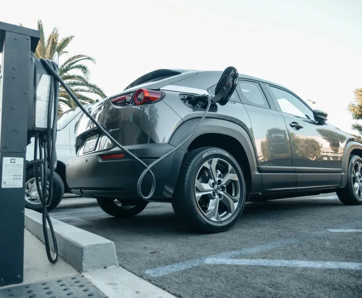 An electric vehicle charges at a charging station. Photo by Kindel Media