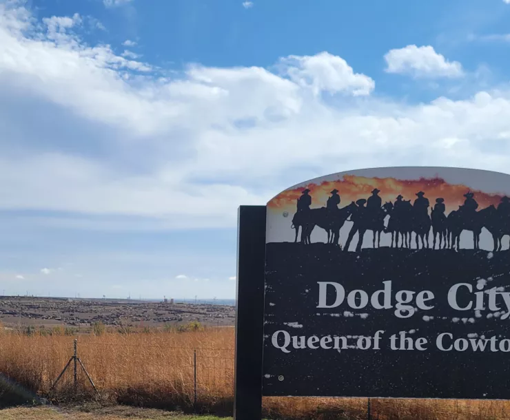 Dodge City, KS scenic overlook sign, blue skies and amber grasses overlooking vast cattle feedlkots