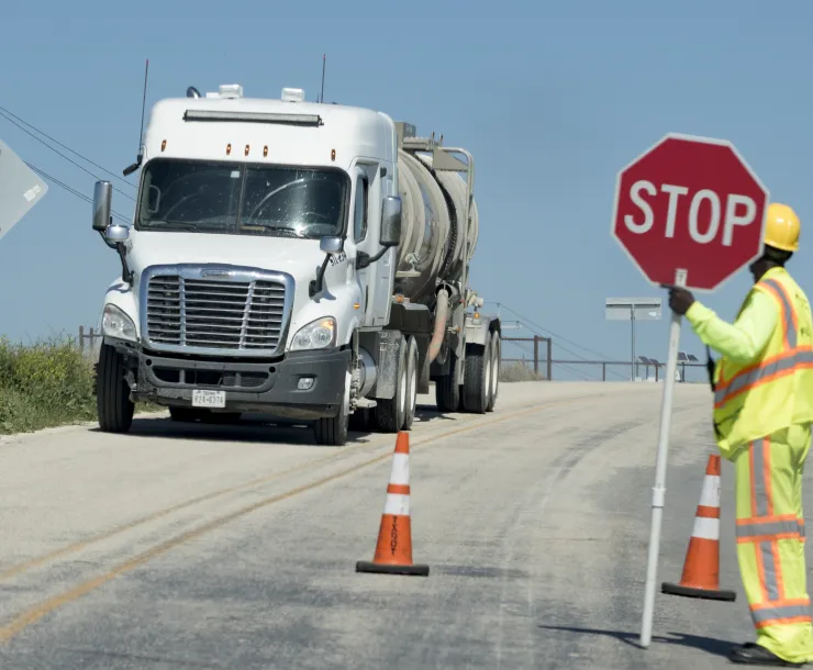 Semi Truck traveling down a road under construction