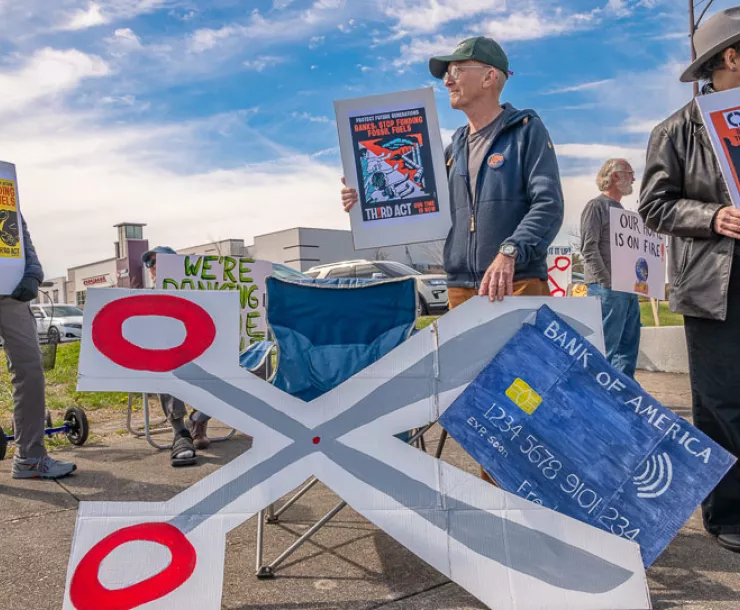 Third Act rally of people with signs against a blue sky