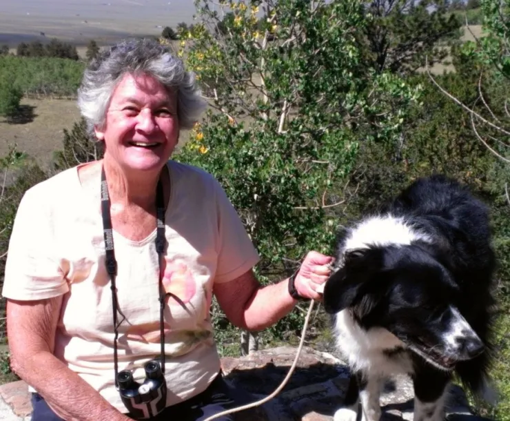 woman with camera and black and white dog 