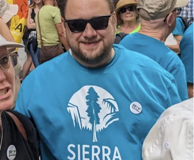 Christopher Shepherd in a blue Sierra Club logo tee, in a group outdoors.
