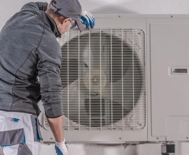 Heat pump and technician. Photo by Tomasz Zajda/Alamy