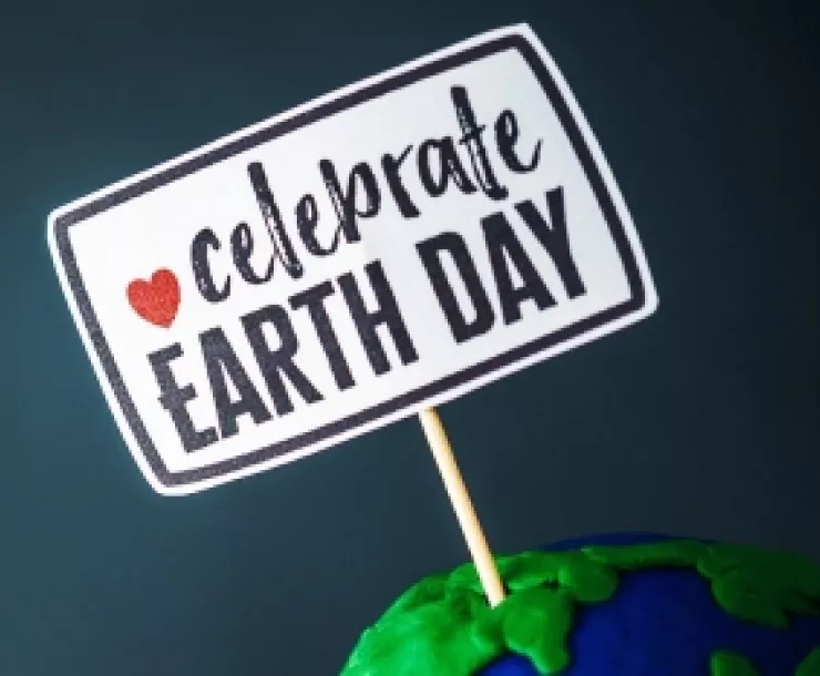 A sign says Celebrate Earth Day with a red heart accent