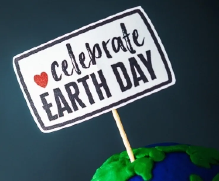 A sign says Celebrate Earth Day with a red heart accent