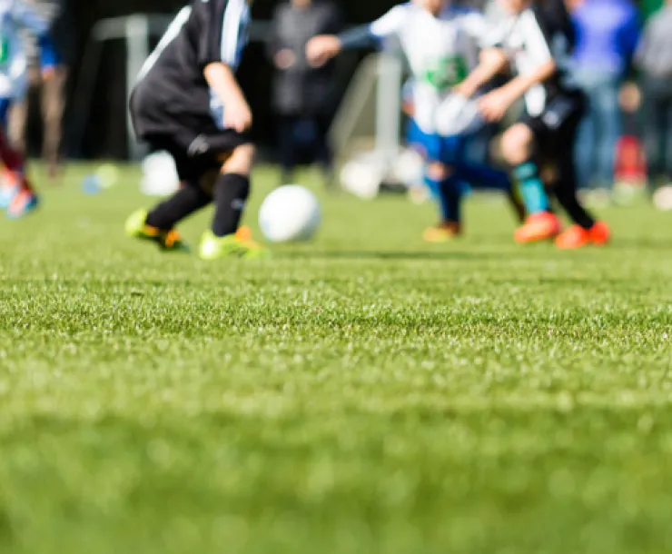 Image of a soccer ball being kicked on artificial turf