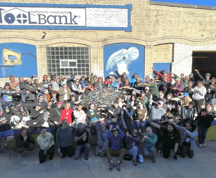 Dumpster dive volunteers point to Rocky the rockfish, who holds more than 800 of the nearly 3,000 beverage containers found in Mr. Trash Wheel’s dumpster. 