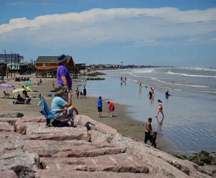 people on the beach in the sand and water