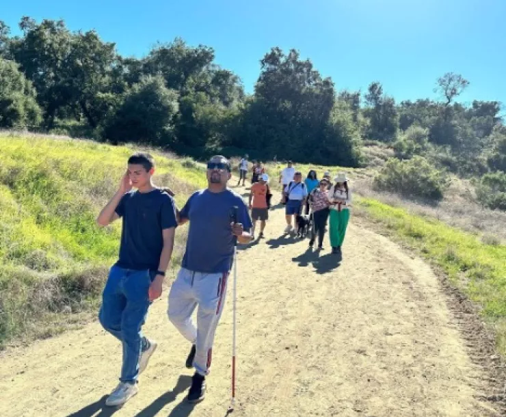 Several visually impaired people hiking with sight guides