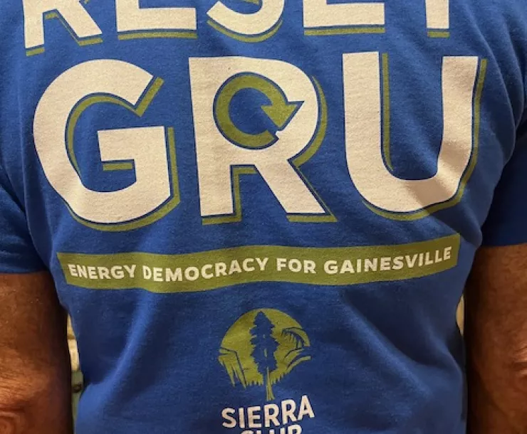 Photo of a back of a T-shirt with the writing RESET GRU - Energy Democracy for Gainesville