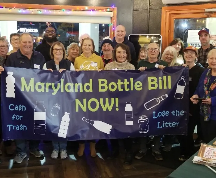 Picture of people holding up banner reading Maryland Bottle Bill Now!