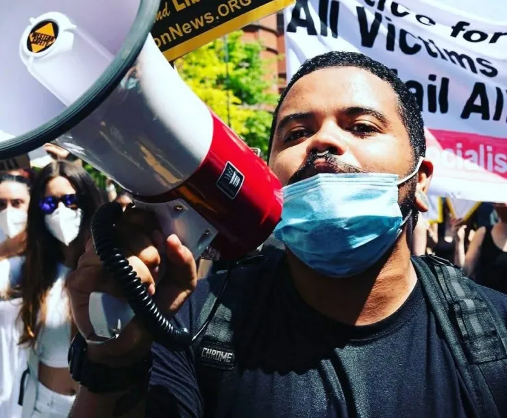 Juan Peralta holds a megaphone and speaks at a rally for justice.