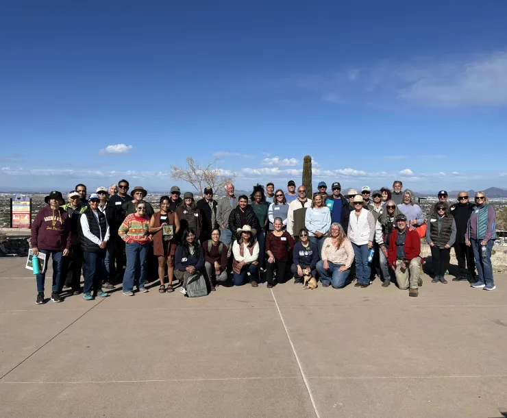 A group of people posing for a photo with the city of Phoenix in the background