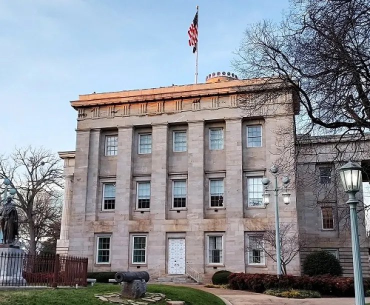 A photograph of the historic NC State Capitol building on a sunny day