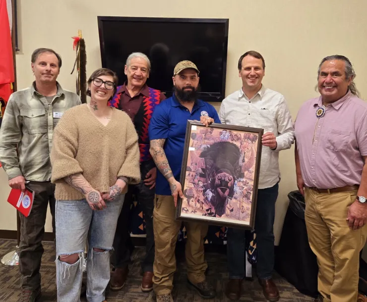 Picture of Julian Matthews and other speakers at the March 2025 Buffalo Summit in Lewiston holding a framed imaged of a buffalo head