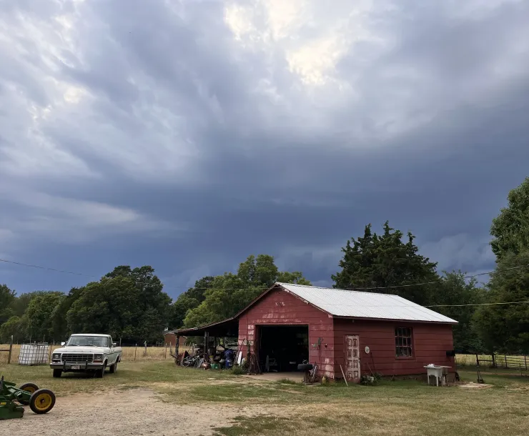 rural farm in North Carolina with old red barn against a cloudy gray sky
