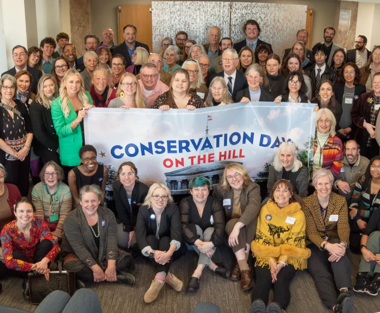 group of people smile and pose in front of banner