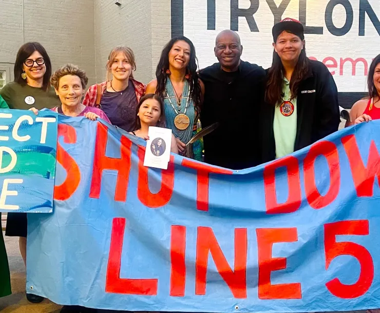Group with banner the reads "Shut Down Line 5" and "Protect Wild Rice"