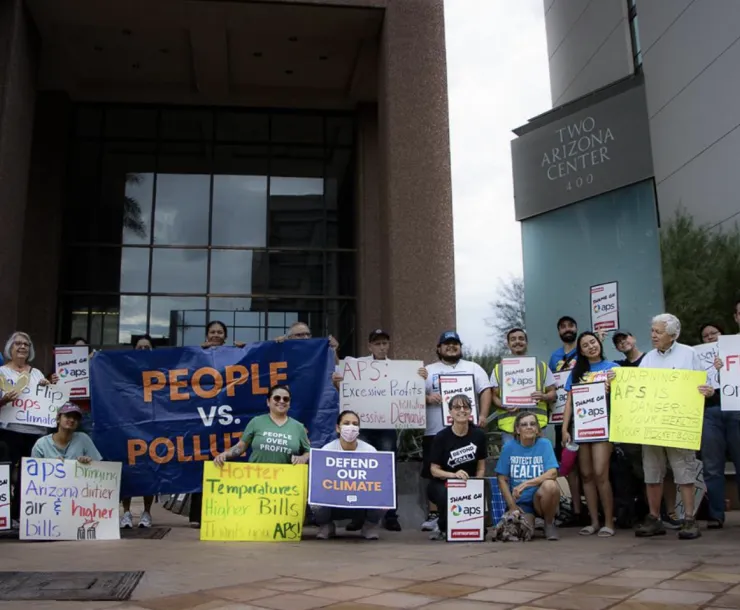 a group of protestors holdling signs in front of APS building