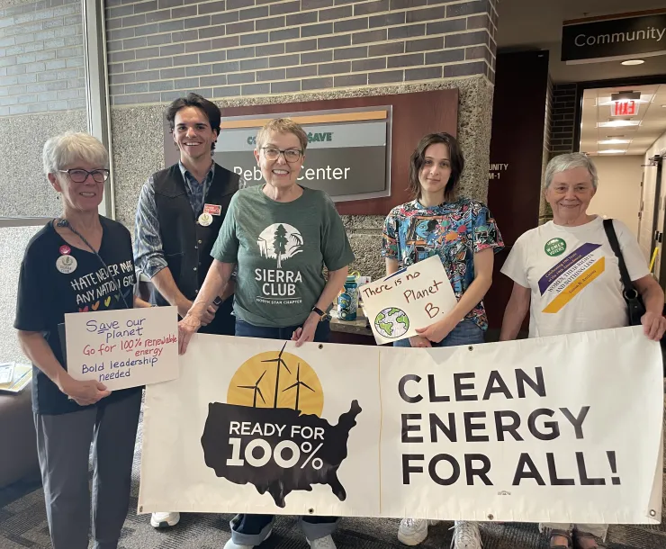 Sierra Club members hold a 100% Clean Energy for All banner