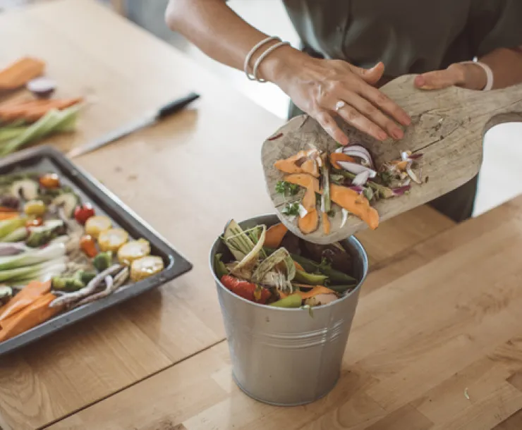 Vegetable scraps being put into a compost container