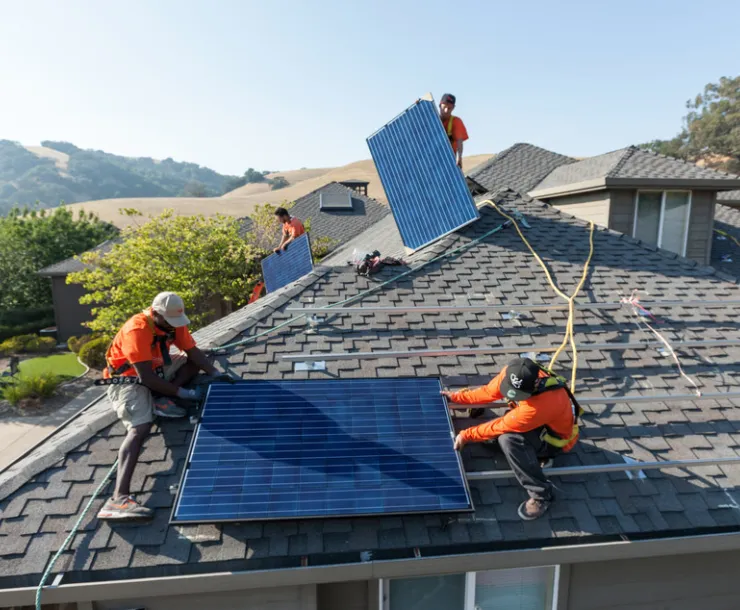 Picture of workers installing solar panels on a roof