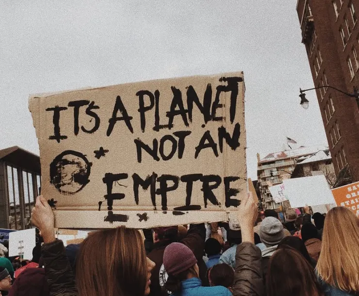 Protestors holding sign that reads "It's a planet not an empire"