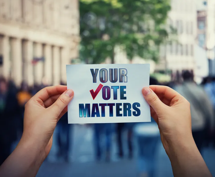 Photo of a person holding a sign that reads Your Vote Matters