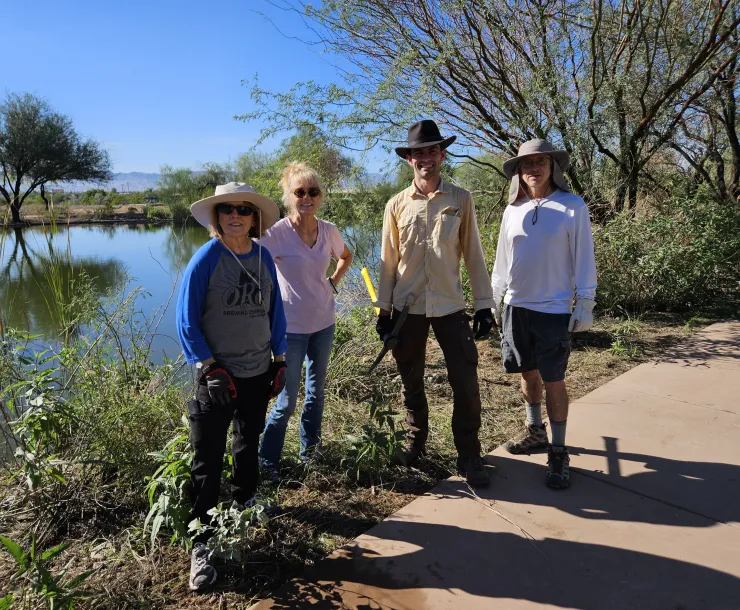 a group poses for a photo next to a river