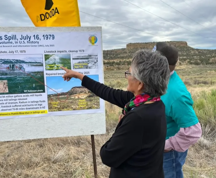 Sierra Club Member Pointing at a Informational poster detailing the Navajo Uranium Village Spill
