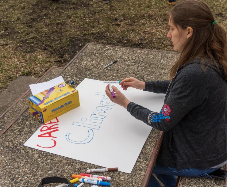 Activist writing "Climate" on a poster
